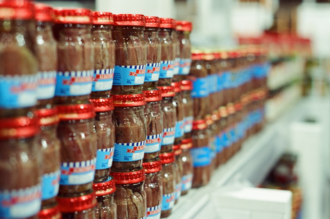 Rows of small bottles with brown liquid on a shelf.