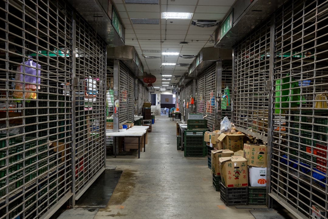 Closed market stalls with metal security shutters and boxes.